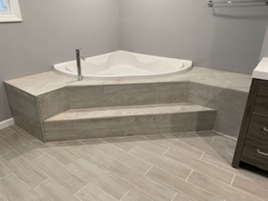 Custom tiled bathroom remodel with corner soaking tub by McNeill Construction LLC in the Fenton, MI area